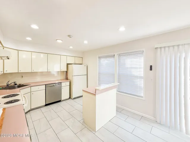 a kitchen with a white cabinets sink and white appliances