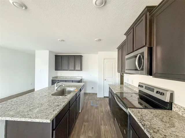 a kitchen with stainless steel appliances granite countertop a stove and a sink