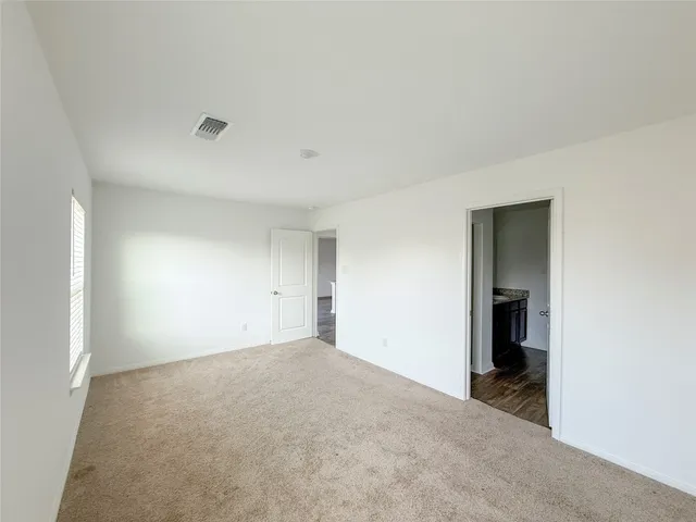 a view of an empty room with closet and entryway