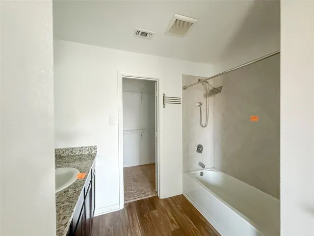 a bathroom with a tub shower and a sink