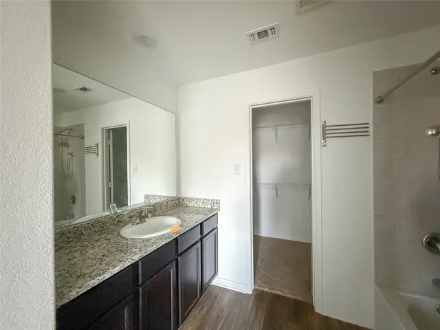 a bathroom with a granite countertop sink and a mirror