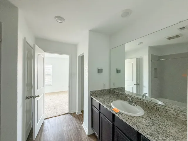 a bathroom with a granite countertop sink and a mirror