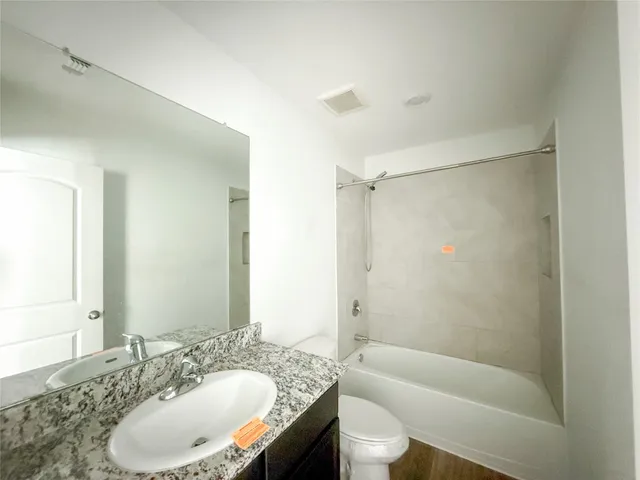 a bathroom with a granite countertop sink toilet and shower