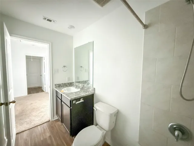 a bathroom with a granite countertop sink toilet and shower