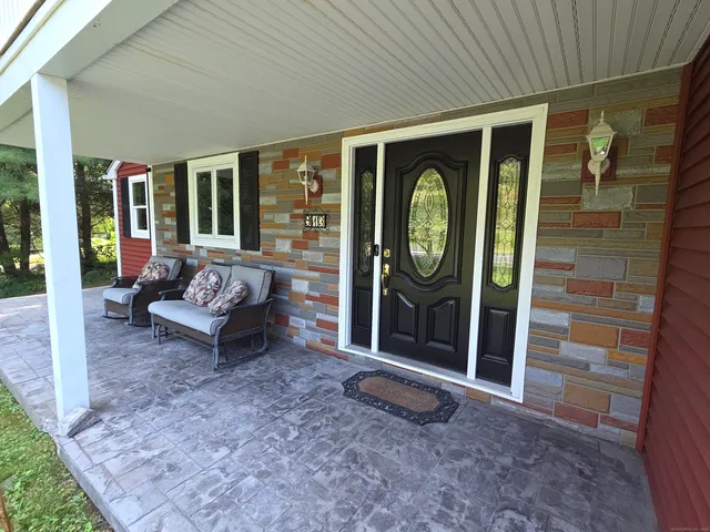 a view of a porch with a table and chairs