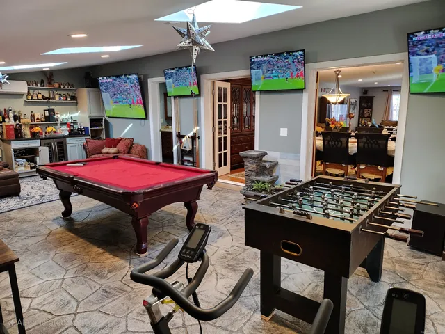 a room with furniture pool table and a flat screen tv