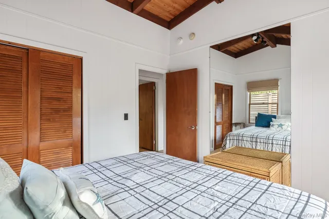 a spacious bedroom with a bed and a flat screen tv