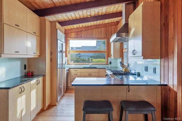 a kitchen with stainless steel appliances granite countertop a sink a stove and a refrigerator