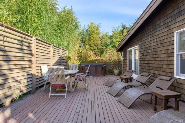 a view of a patio with table and chairs with wooden floor and fence