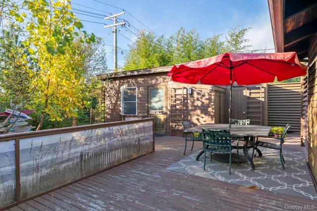 a view of a house with wooden deck and furniture