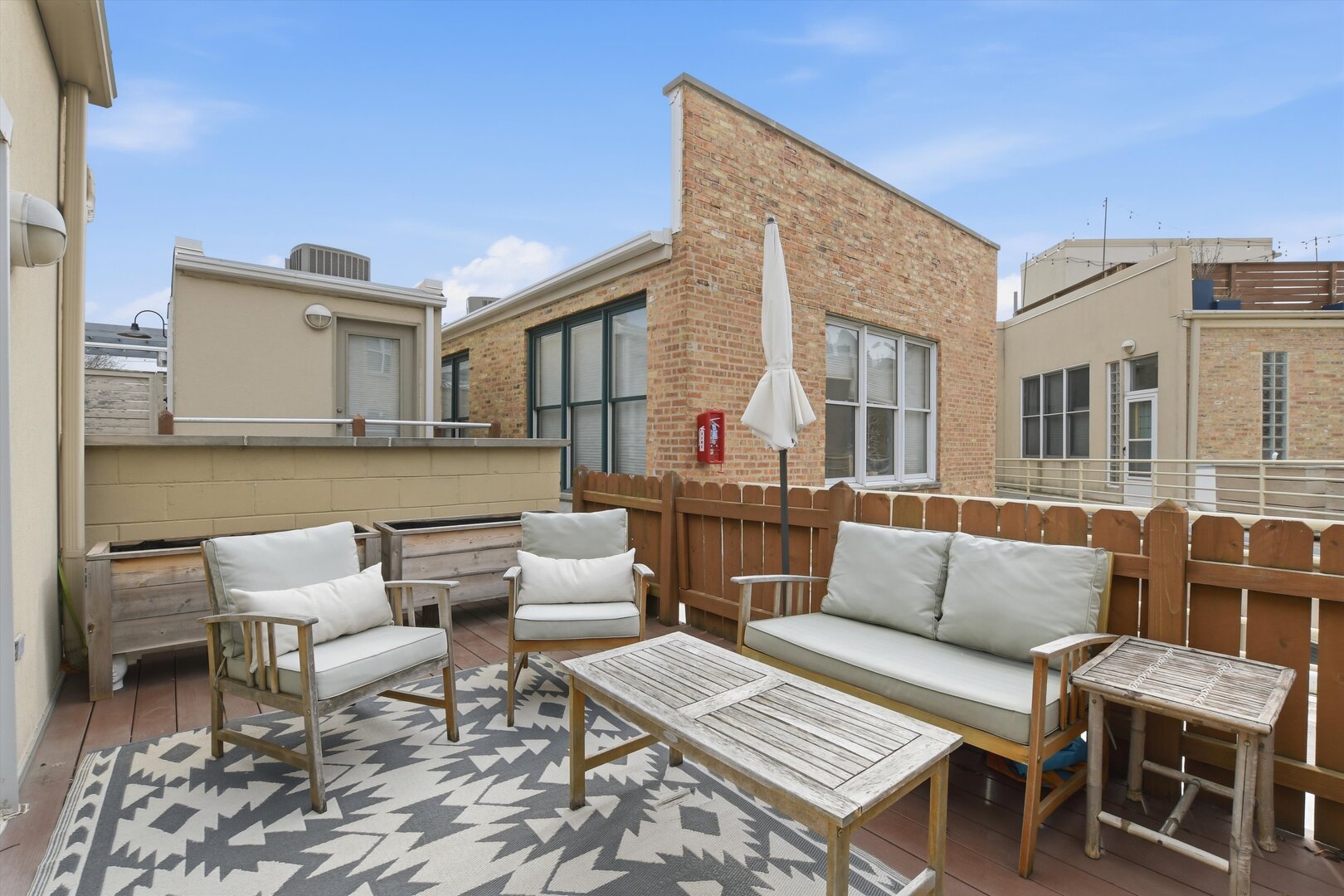 1235 West George Street, Unit 103 Chicago, IL 60657 - Photo 23 of 28 a view of a patio with couches and a dining table and chairs with wooden floor