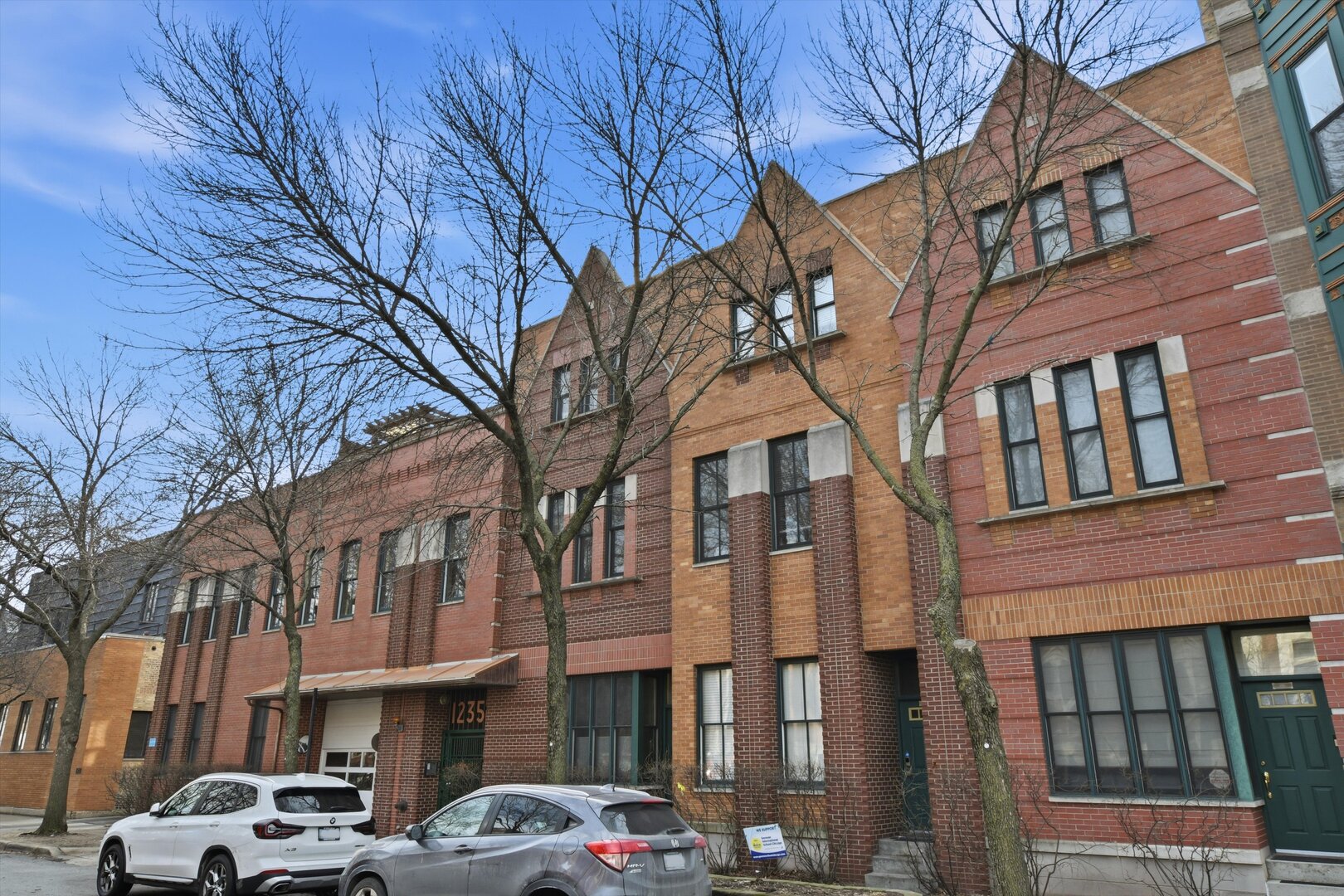 1235 West George Street, Unit 103 Chicago, IL 60657 - Photo 28 of 28 a couple of cars parked in front of brick building