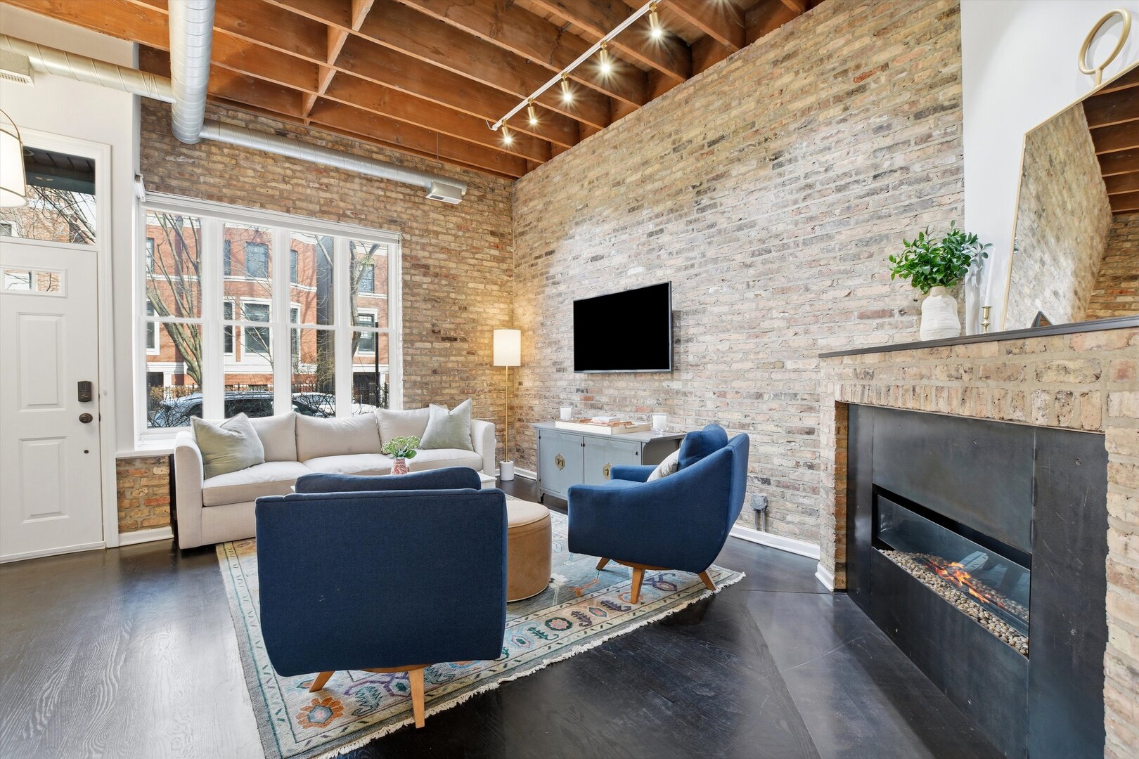 1235 West George Street, Unit 103 Chicago, IL 60657 - Photo 4 of 28 a living room with furniture a flat screen tv and a fireplace