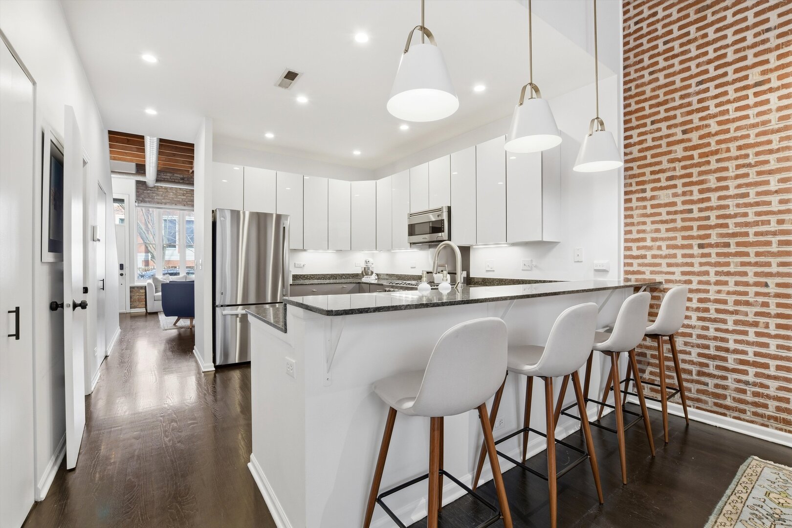 1235 West George Street, Unit 103 Chicago, IL 60657 - Photo 6 of 28 a kitchen with stainless steel appliances a refrigerator a stove a sink dishwasher with a dining table and chairs