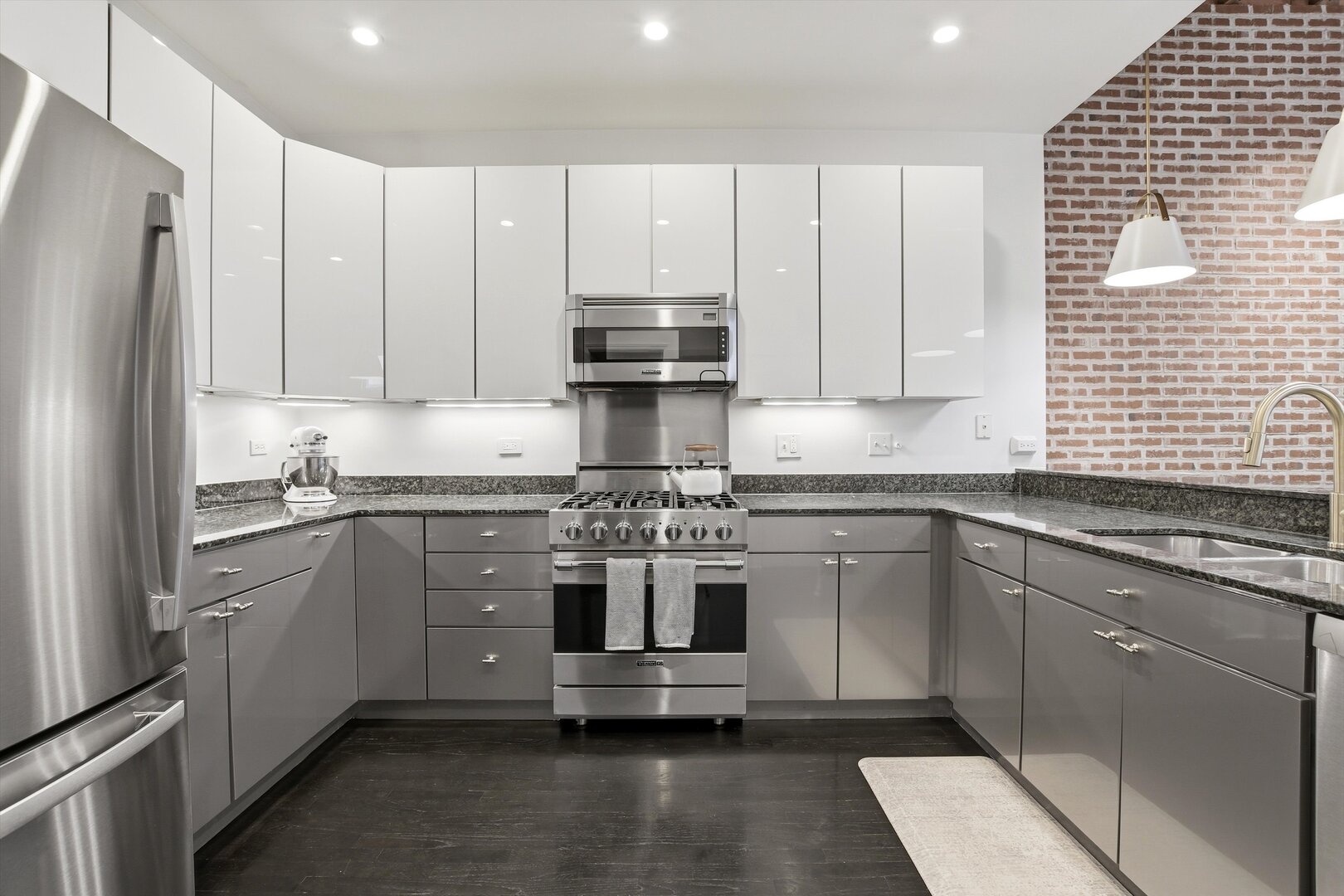 1235 West George Street, Unit 103 Chicago, IL 60657 - Photo 7 of 28 a kitchen with kitchen island granite countertop white cabinets and stainless steel appliances