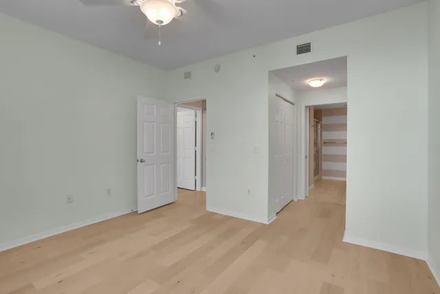 an empty room with a window and a fan