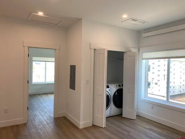 a view of a hallway with wooden floor and closet