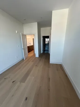 an empty room with wooden floor and fireplace