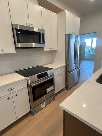 a kitchen with stainless steel appliances a stove microwave and refrigerator