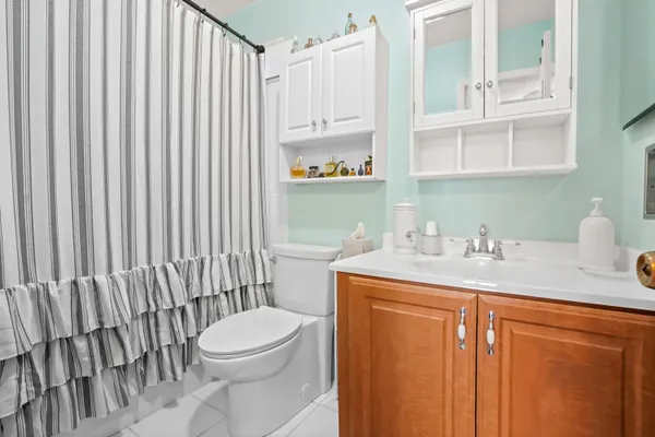 a bathroom with a granite countertop sink vanity mirror and toilet