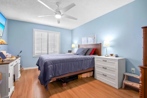 a bedroom with a bed and a flat tv screen on dresser