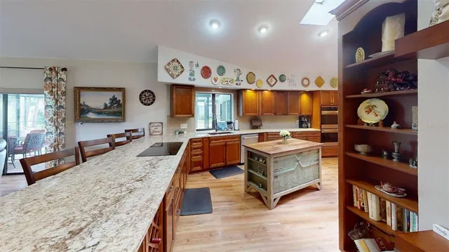 a living room with stainless steel appliances kitchen island granite countertop furniture and a view of living room