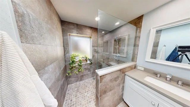 a bathroom with a granite countertop sink a toilet and shower