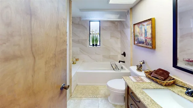a bathroom with a sink toilet vanity and tub