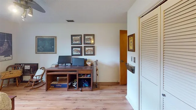 a view of a workspace with furniture and wooden floor