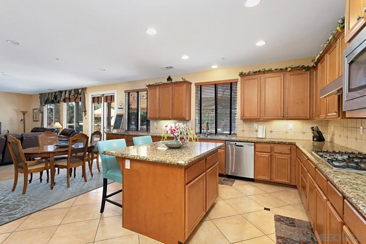 604 Hidden Trails Road Escondido, CA 92027 - Photo 14 of 49 a kitchen with stainless steel appliances granite countertop a stove top oven a sink dishwasher and cabinets