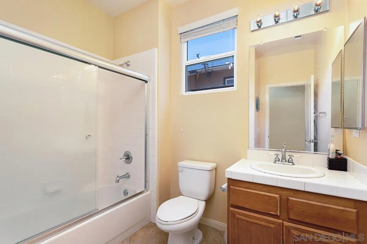 604 Hidden Trails Road Escondido, CA 92027 - Photo 19 of 49 a bathroom with a sink a toilet a mirror and shower
