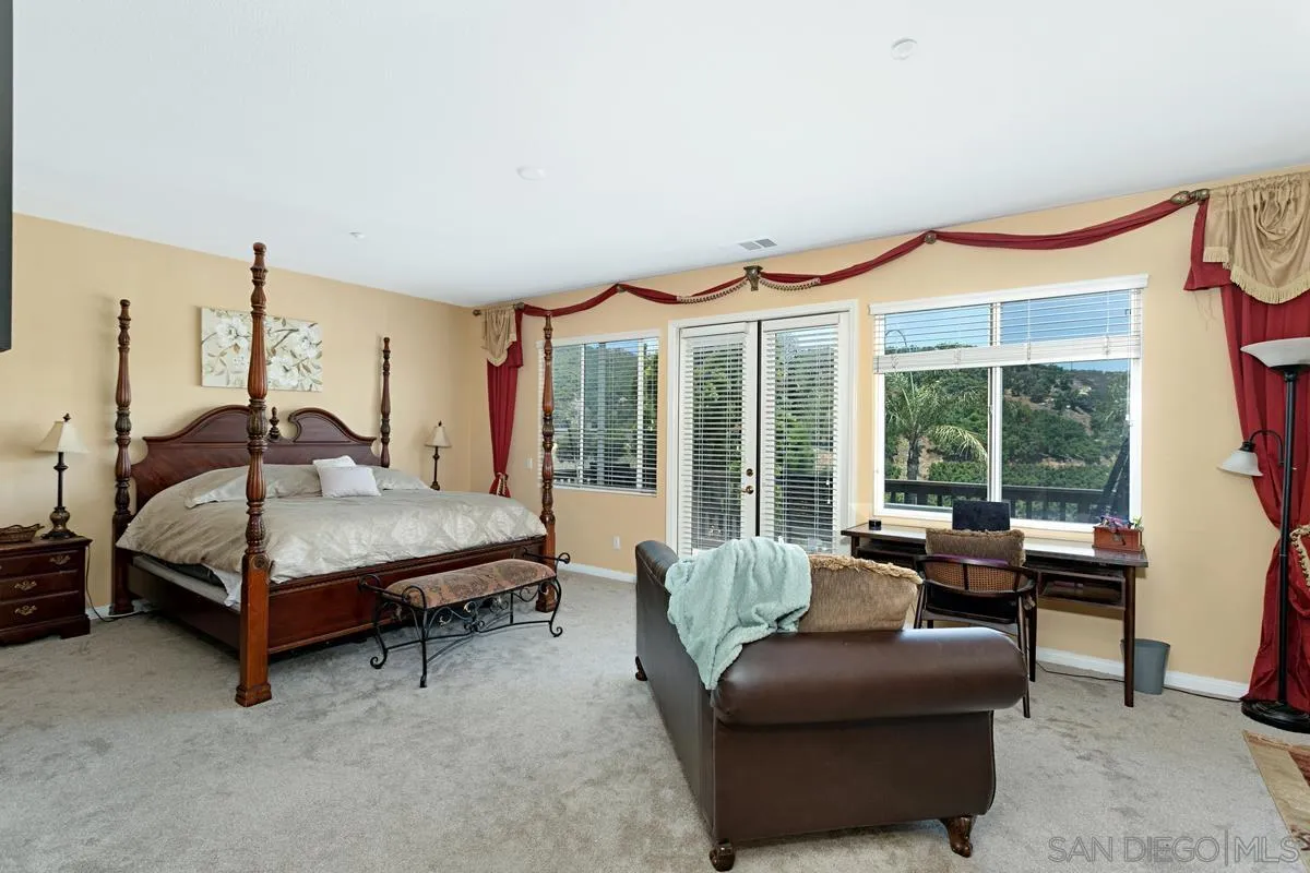 604 Hidden Trails Road Escondido, CA 92027 - Photo 29 of 49 a bedroom with a bed couch and a large window