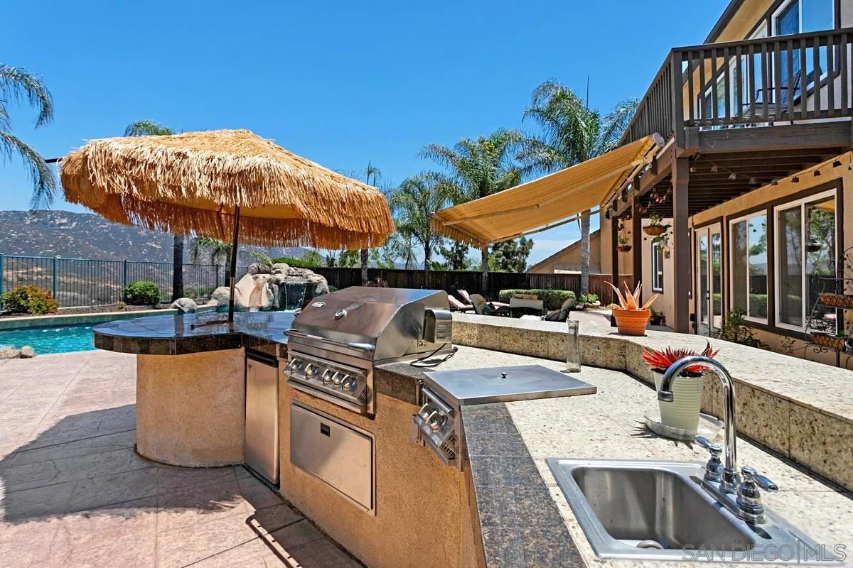 604 Hidden Trails Road Escondido, CA 92027 - Photo 43 of 49 a view of a patio with a table and chairs under an umbrella