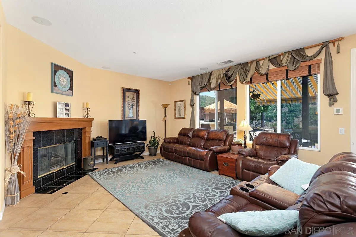 604 Hidden Trails Road Escondido, CA 92027 - Photo 8 of 49 a living room with furniture a large window and a fireplace