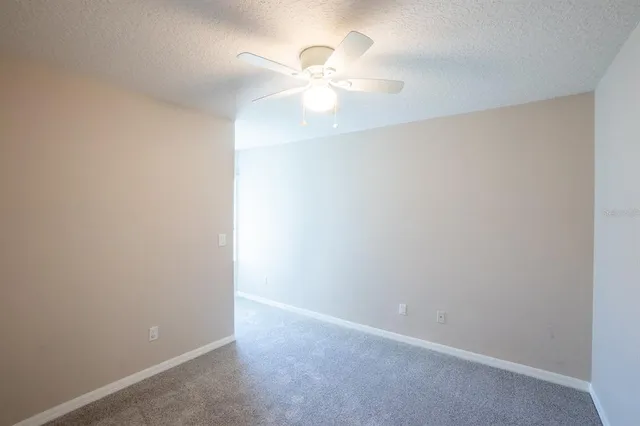 an empty room with a chandelier fan and a chandelier fan
