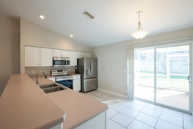 a kitchen with stainless steel appliances a refrigerator and a stove top oven