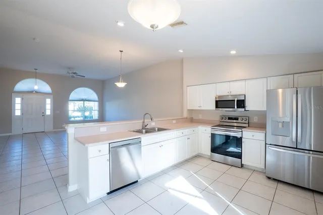 a large kitchen with stainless steel appliances granite countertop a stove a sink and a refrigerator