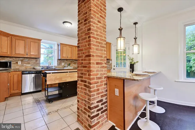 a kitchen with granite countertop a stove a sink and a microwave