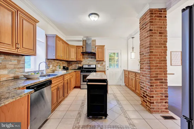 a kitchen with stainless steel appliances granite countertop a stove a sink and a refrigerator