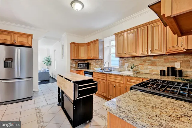 a kitchen with stainless steel appliances granite countertop a stove a sink dishwasher and a refrigerator