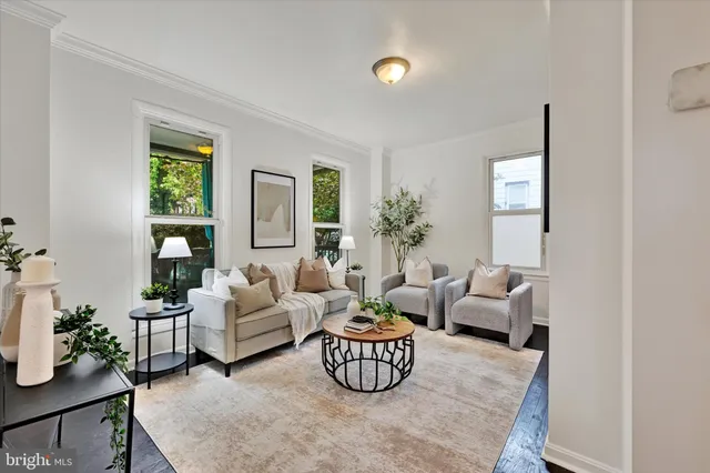 a living room with furniture wooden floor and a large window