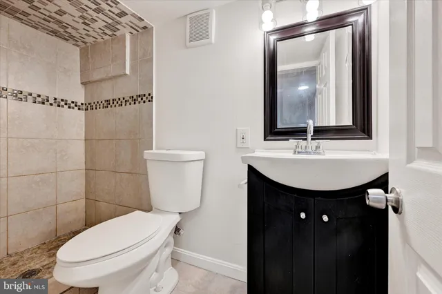 a bathroom with a toilet a sink and mirror