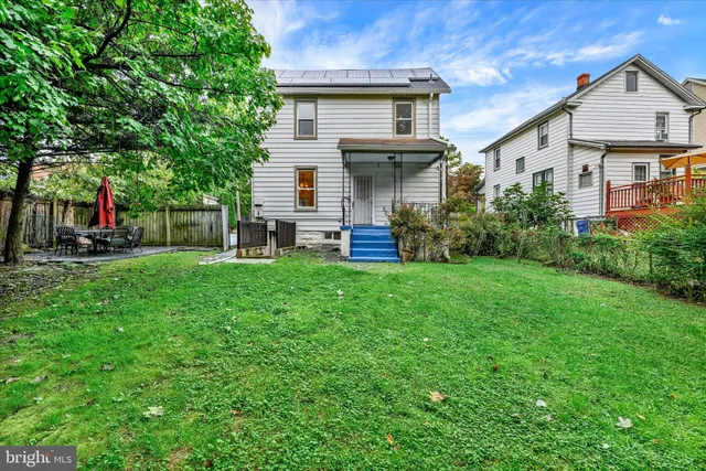 a front view of a house with a yard and trees