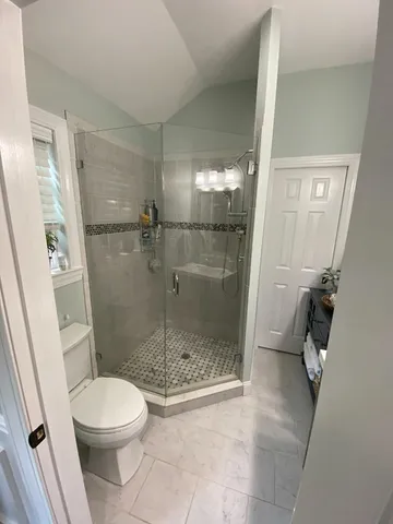 a bathroom with a toilet and a shower