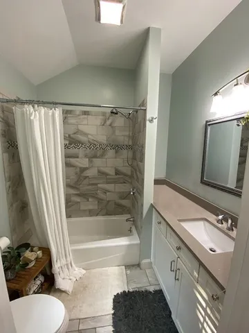 a bathroom with a granite countertop sink toilet and shower