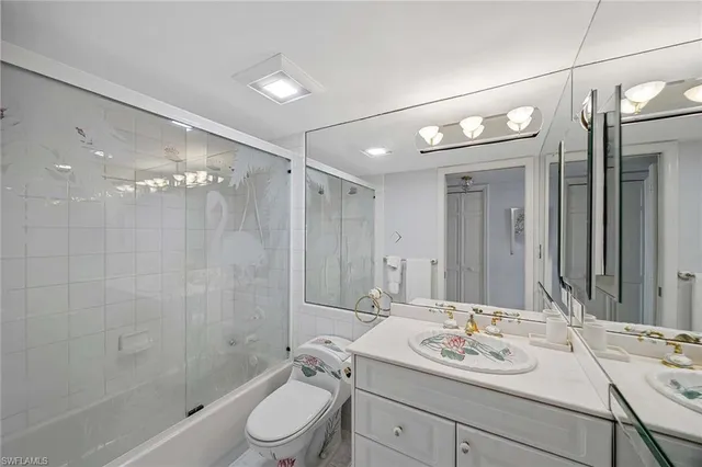 a bathroom with a double vanity sink toilet mirror and shower
