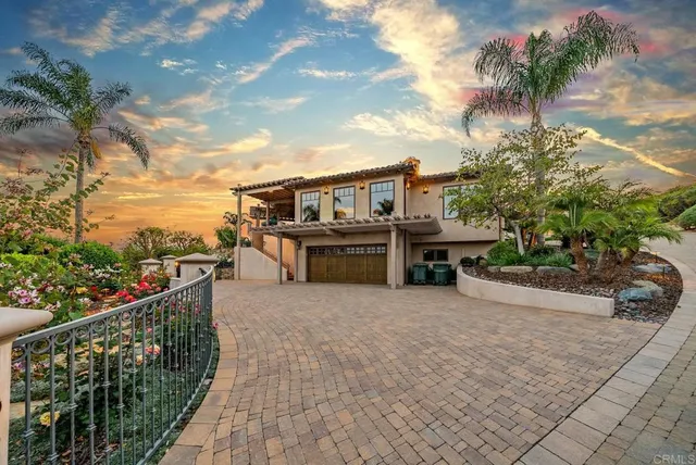 a view of a brick house with a small yard and plants
