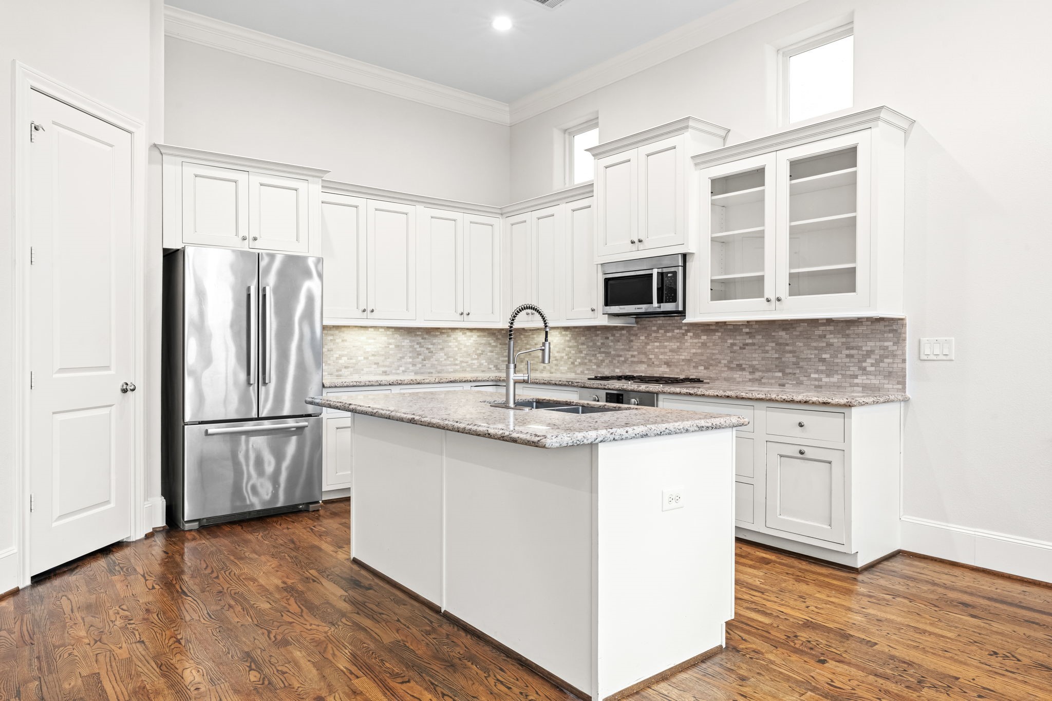5621 Cohn Meadow Lane Houston, TX 77007 - Photo 7 of 35 Beautifully appointed kitchen with granite countertops, stainless steel appliances, and under-cabinet lighting, offering both style and functionality in an open-concept layout.