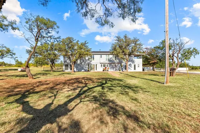 a view of yard with tree in the background