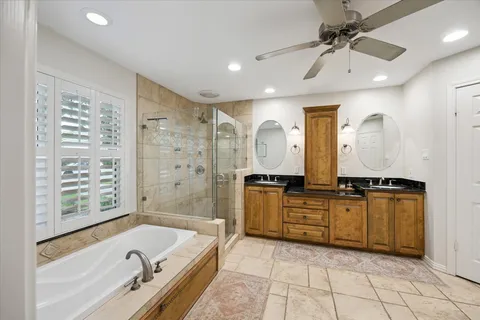 a bathroom with a granite countertop sink a mirror a bathtub and shower
